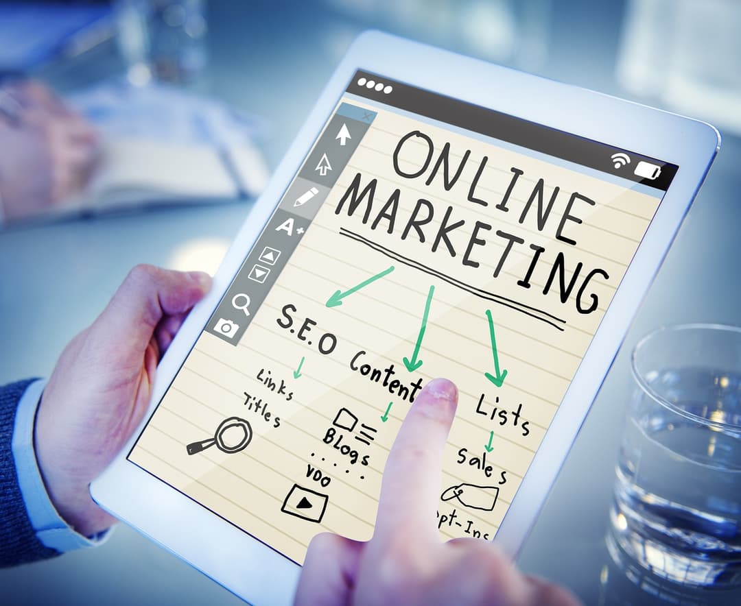 Tablet mit handschriftlicher Darstellung verschiedener Online-Marketing-Maßnahmen wie SEO, Content, Listen und Blogs