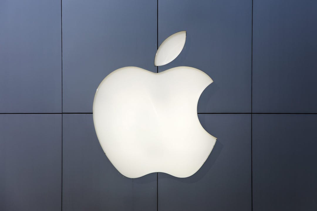 Post mit beleuchtetem Apple Logo auf dunkler Wand