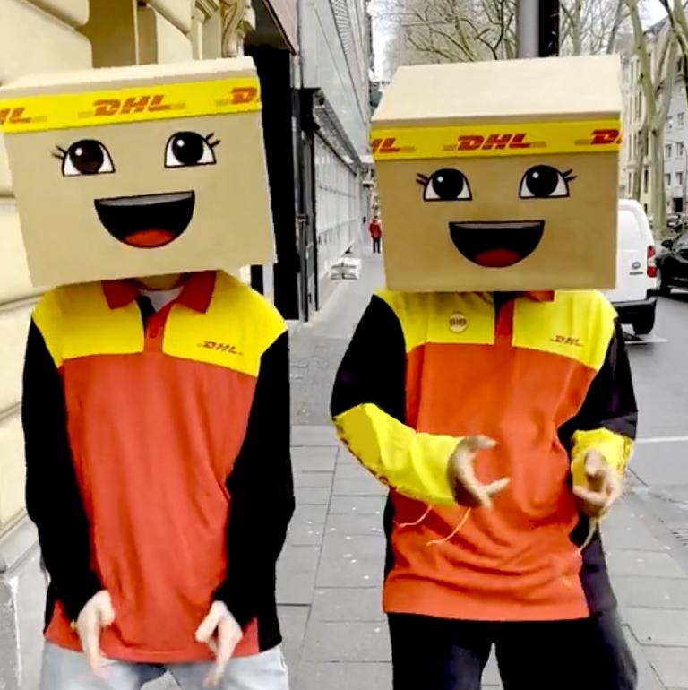 Tik-Tok Video-Kampagne für DHL eCommerce: Zwei Personen in DHL Kleidung mit jeweils einer Boxie-Maske auf dem Kopf