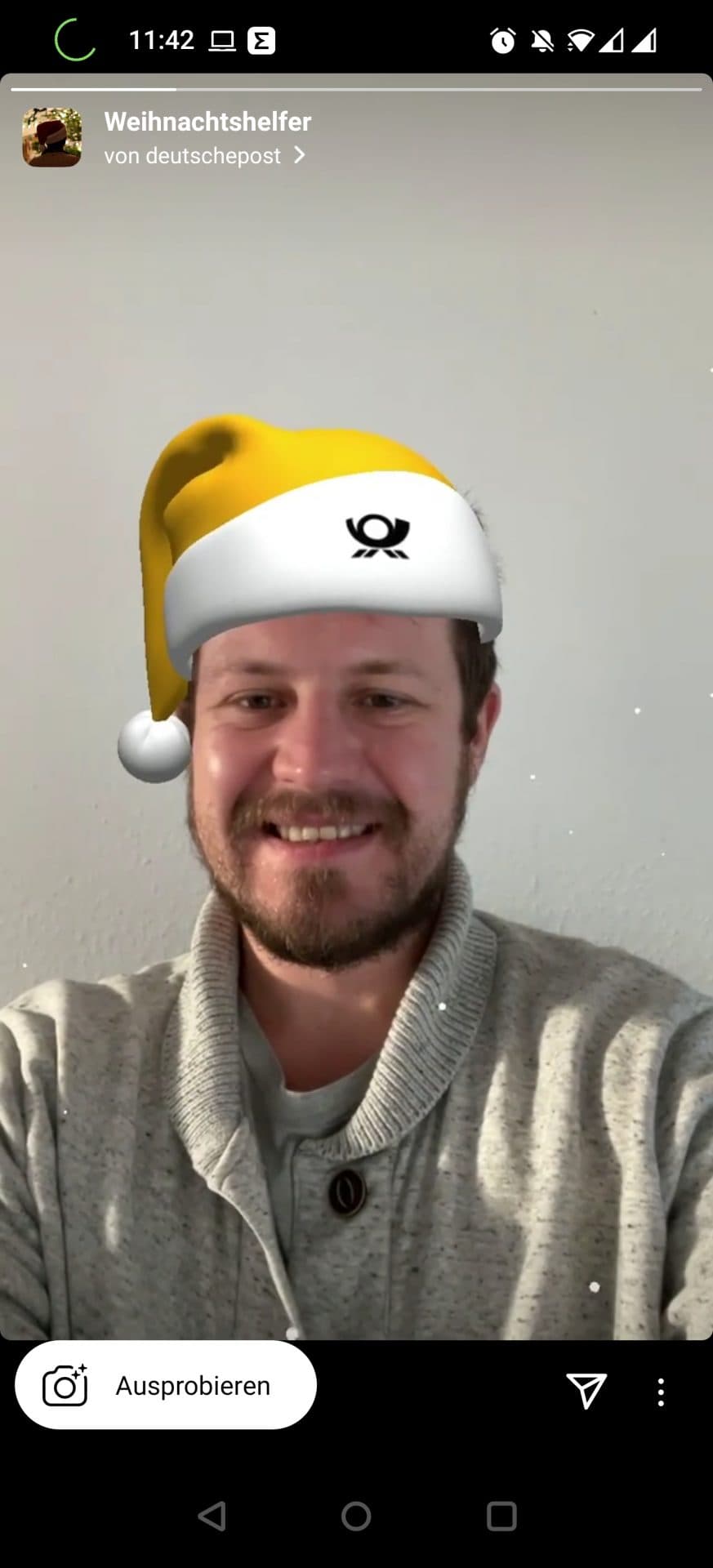 Ein Mann mit gelb-weißer DHL-Weihnachtsmannmütze. 