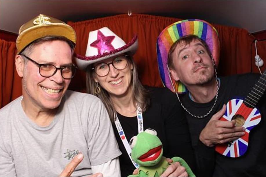 Rheindigital-Team mit Kreativität und Spaß auf der DMEXCO 2025 Das Rheindigital-Team bei der DMEXCO 2025 in der Fotobox: Oliver Funke, Kate Butkus und Sebastian Meltz mit Verkleidungen und Accessoires.