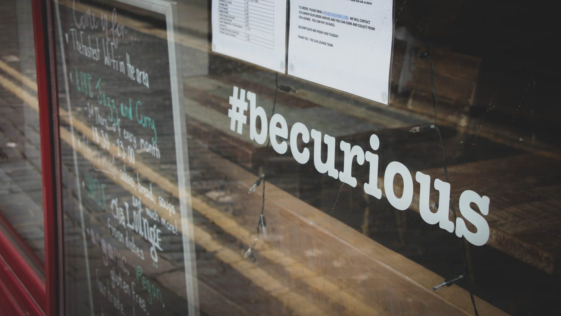 Ein Schaufenster mit dem Schriftzug “#becurious”.